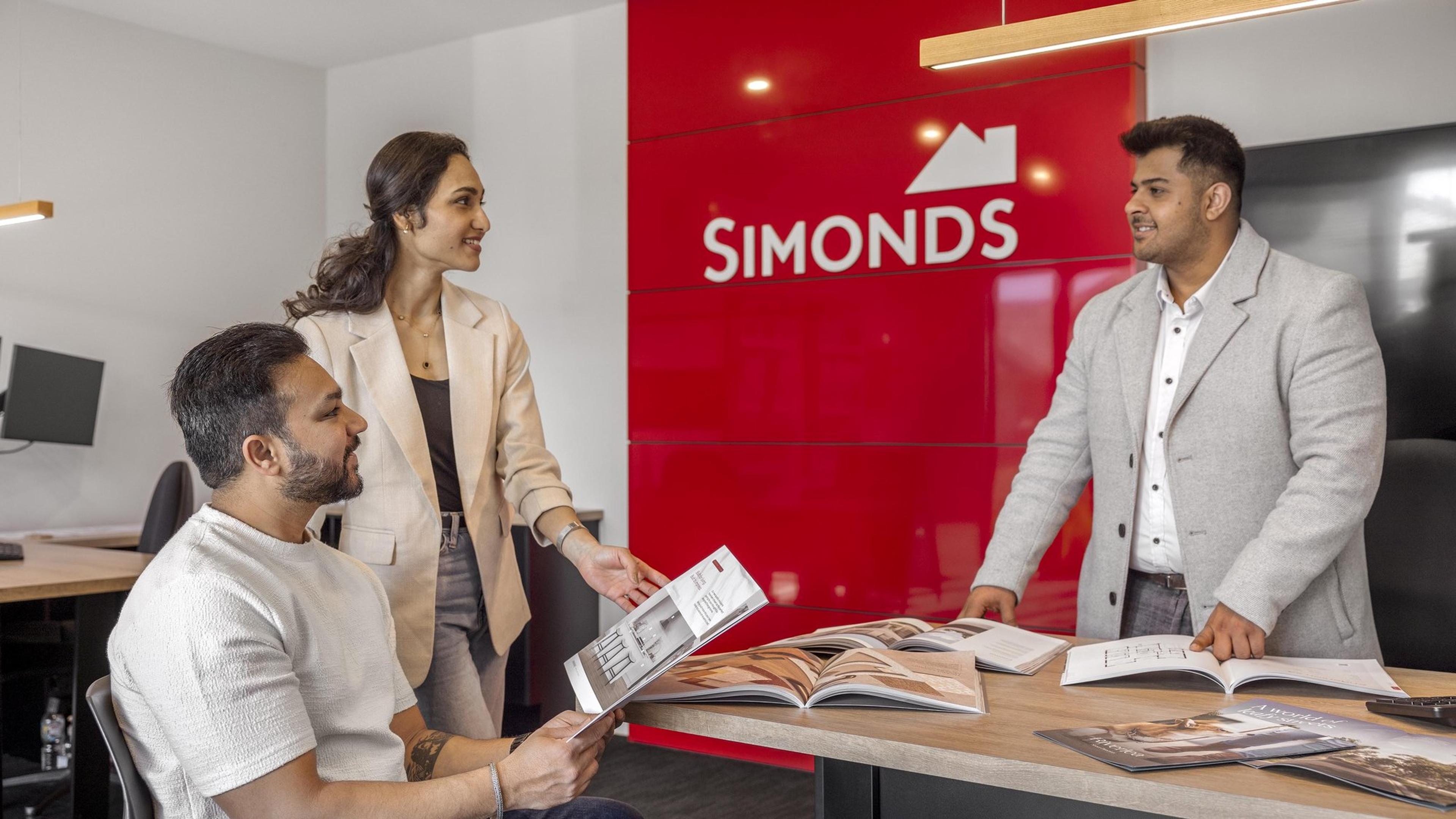 A couple looking through home design brochures with a Simonds Homes consultant