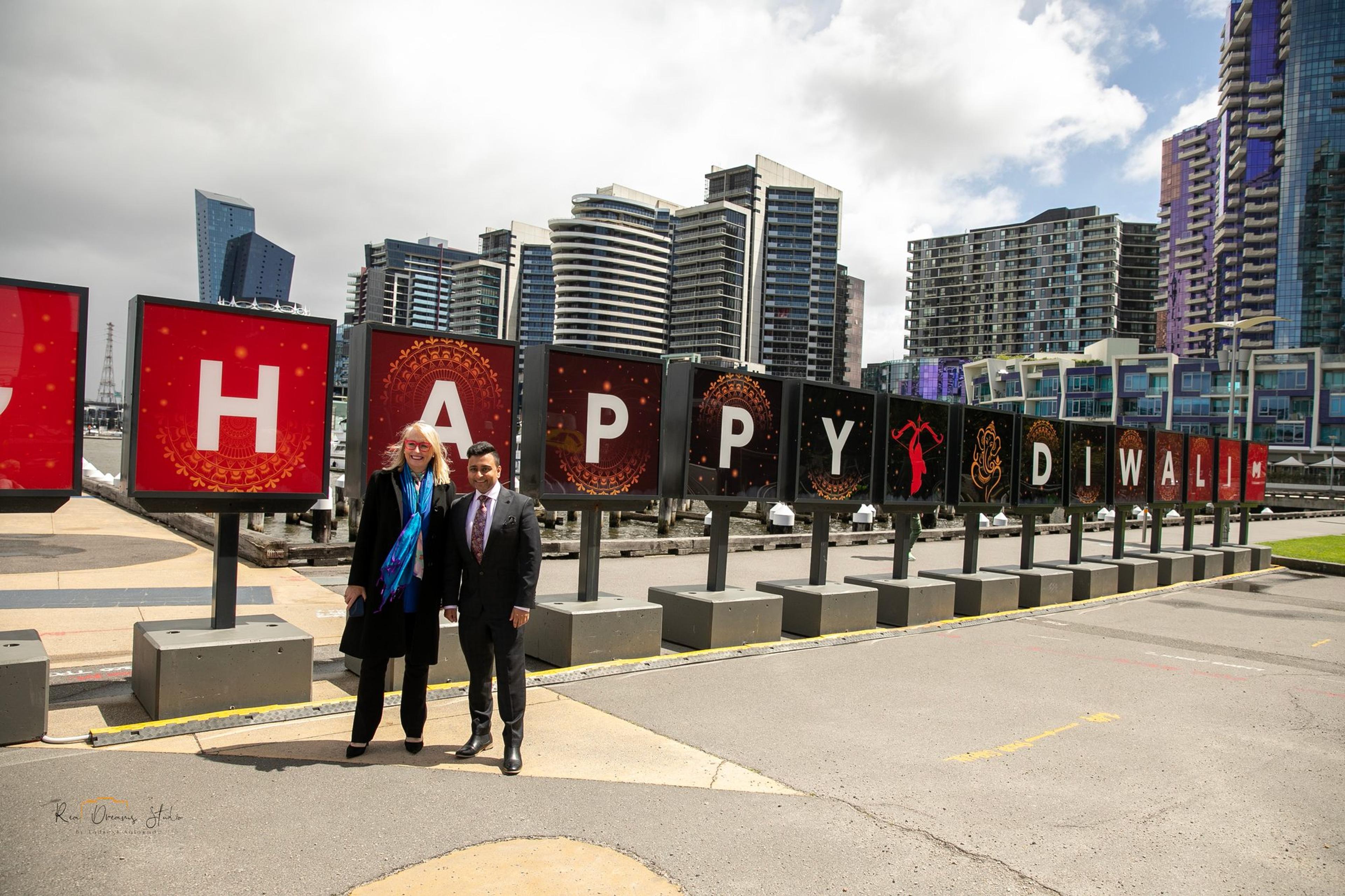 Two guests take the first photo at the H of the HAPPY DIWALI sign