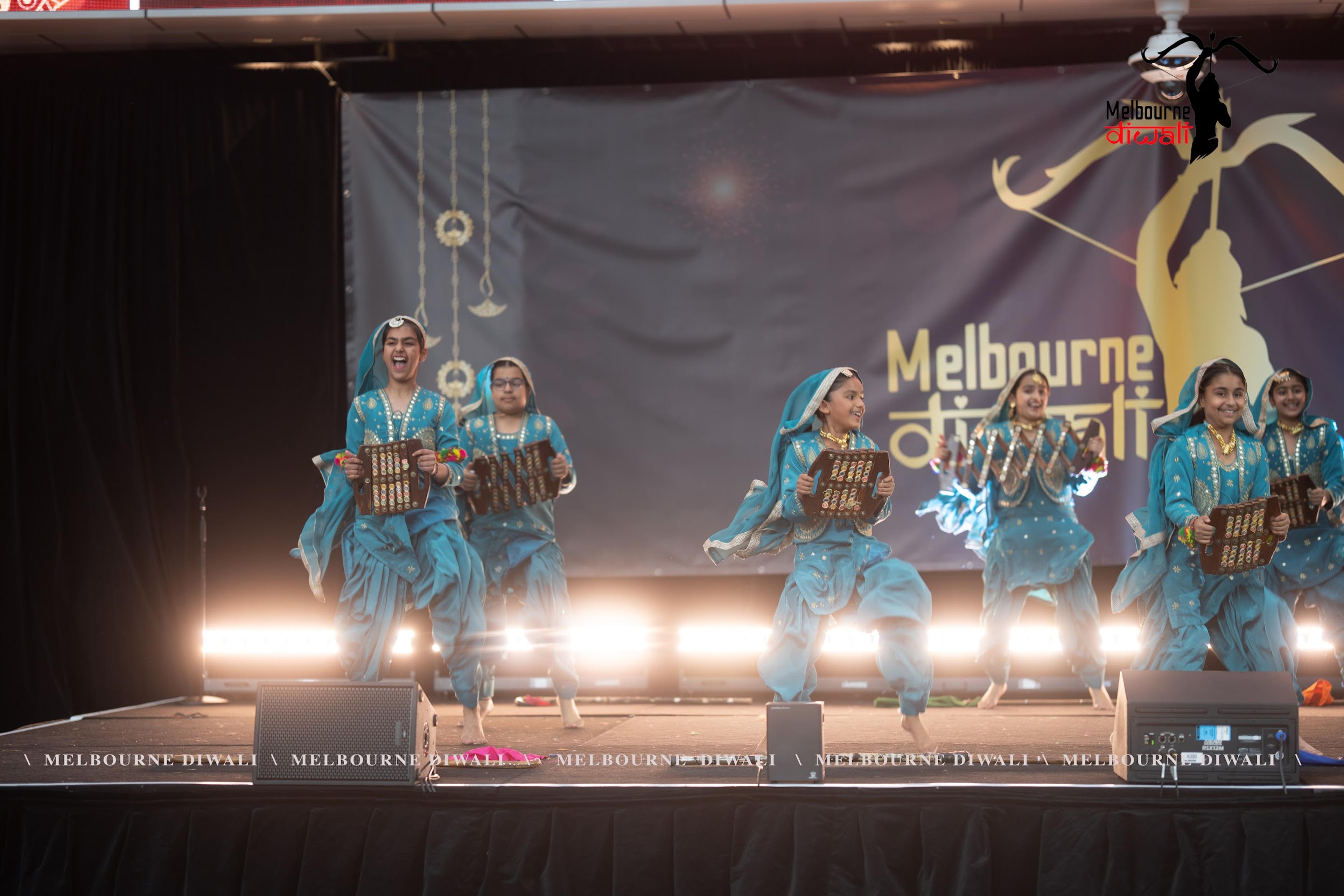 Young dancers mid-jump during a giddha routine at Melbourne Diwali 2025