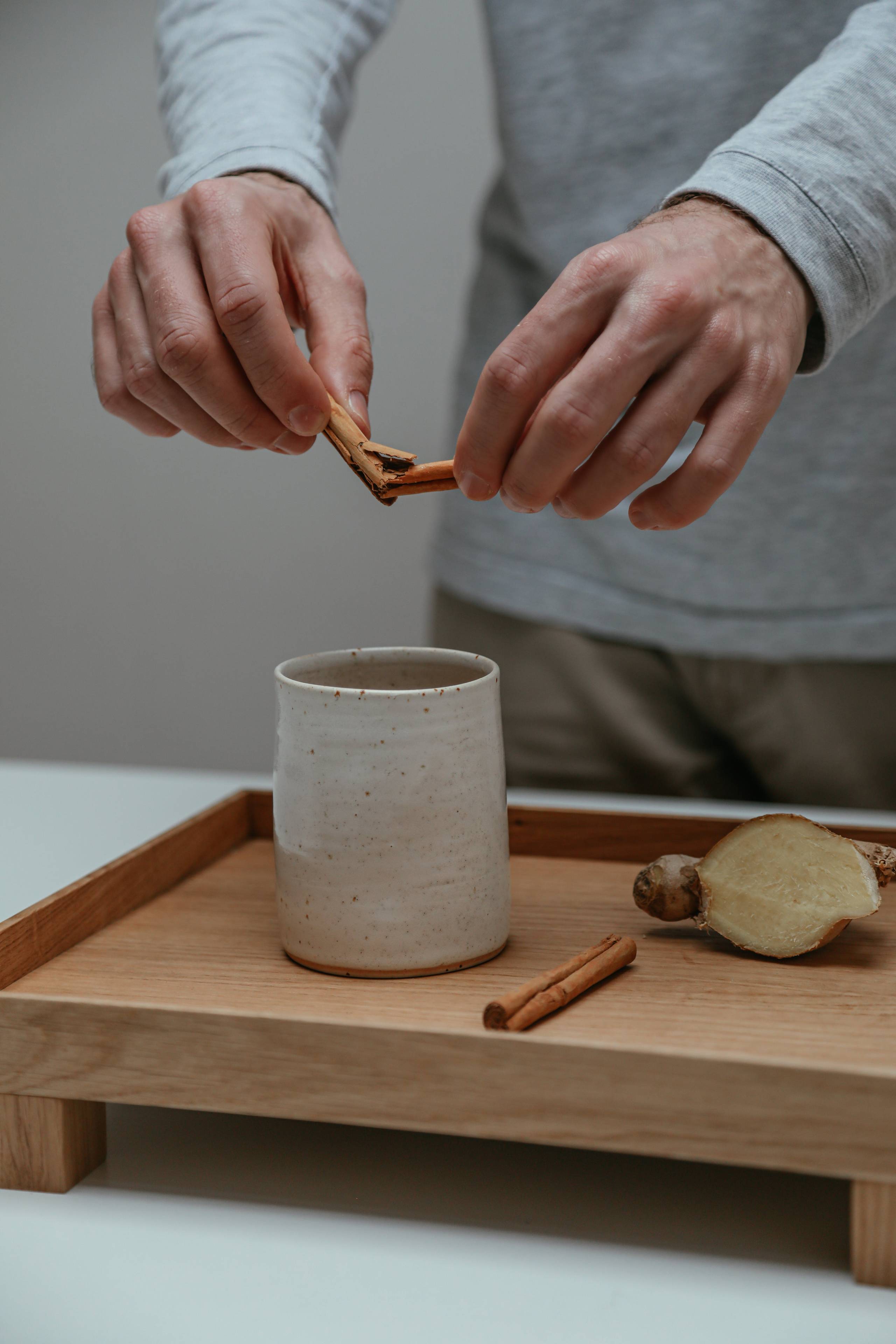pouring cinnamon into a mug