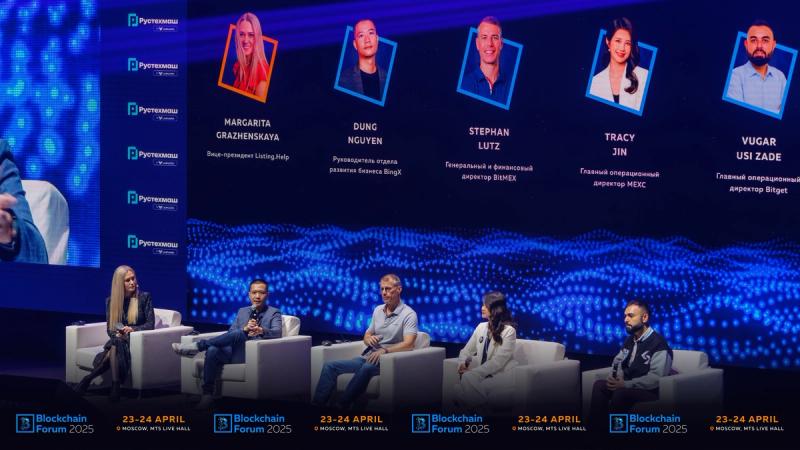 Five people sitting on a couch on a convention stage, speaking during a panel discussion