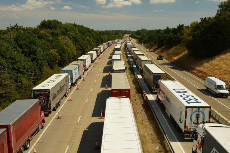 Vue aérienne de files de camions sur une autoroute à deux chaussées.