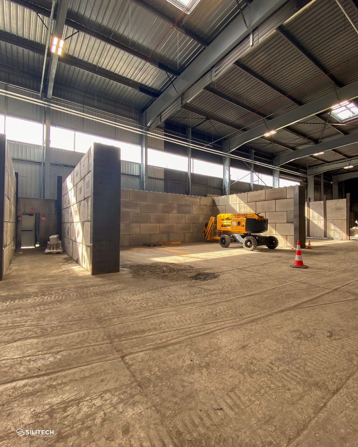 Cellules de stockage compartimentées avec des murs en blocs béton empilables VBloc, à l'intérieur d'un hangar agricole