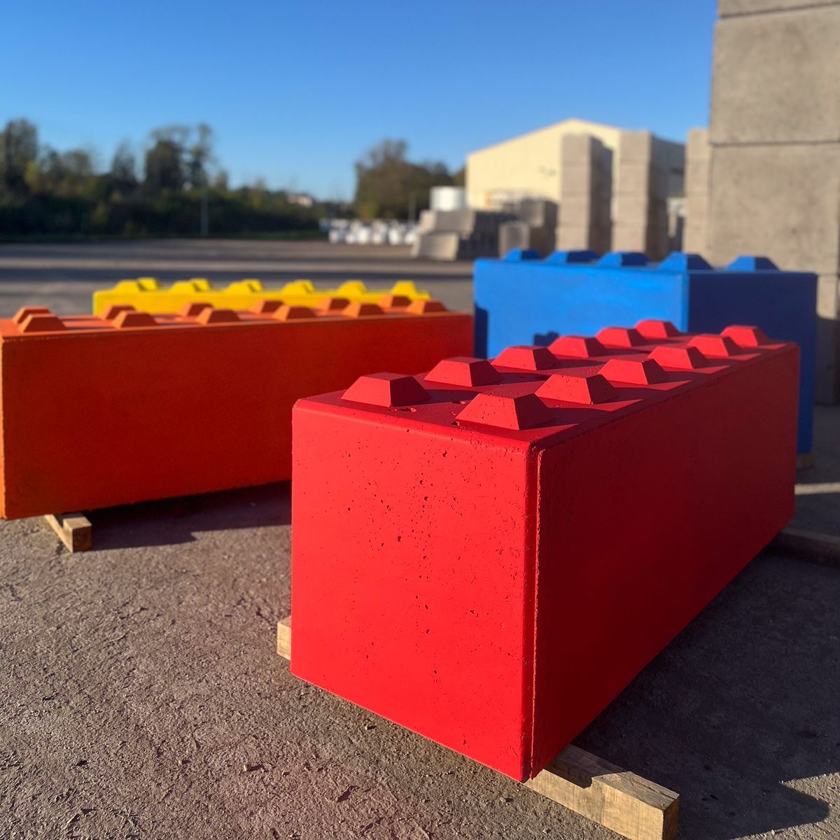 Blocs béton peints en rouge, jaune et bleu pour une sécurisation temporaire