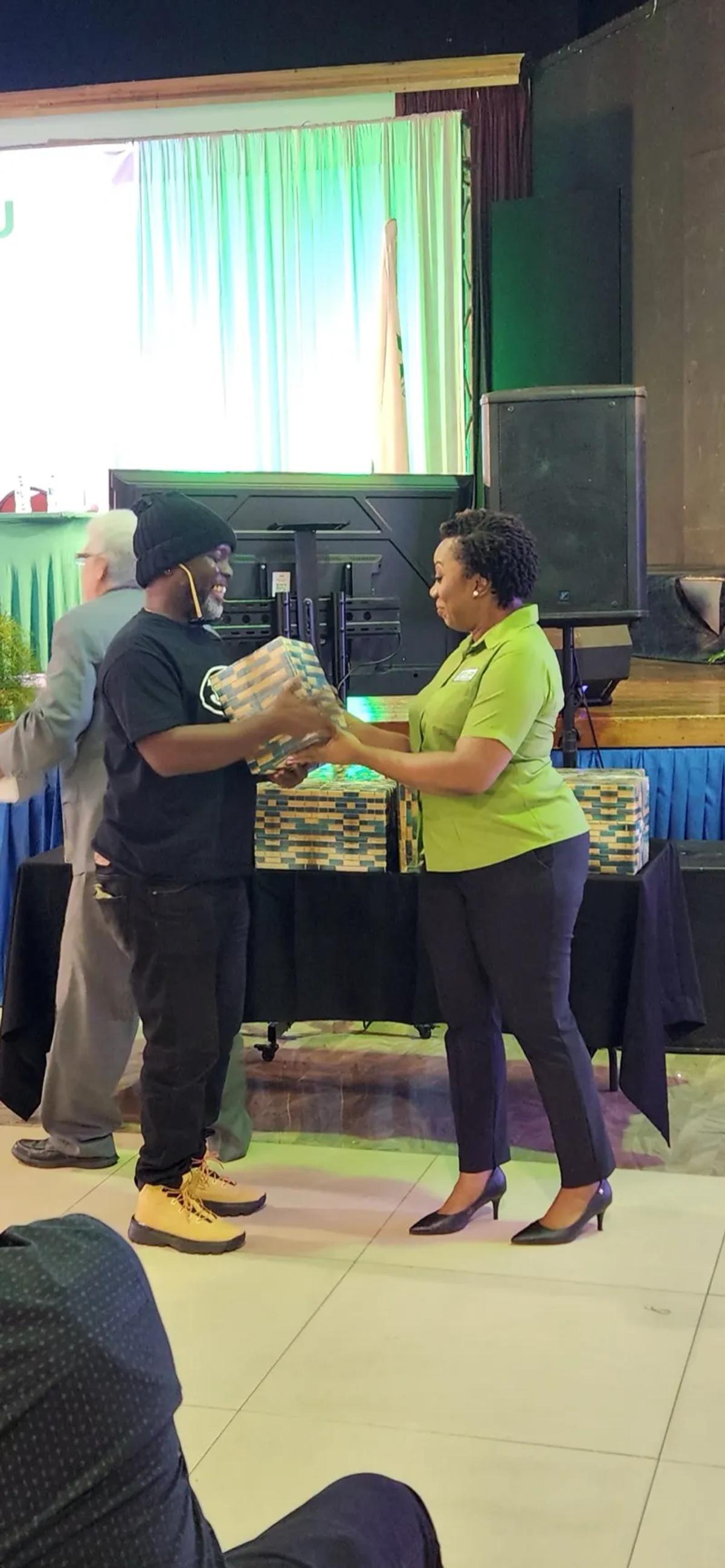 TACU staff member presenting a gift to a member during the 72nd AGM