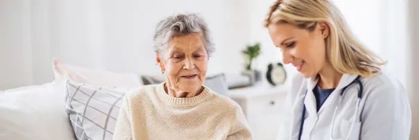 Senior and caregiver coversating on the couch