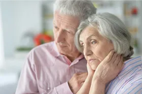 Elderly couple comforting each other after learning of a dementia diagnosis.