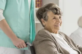 Elderly woman who is smiling in wheelchair.