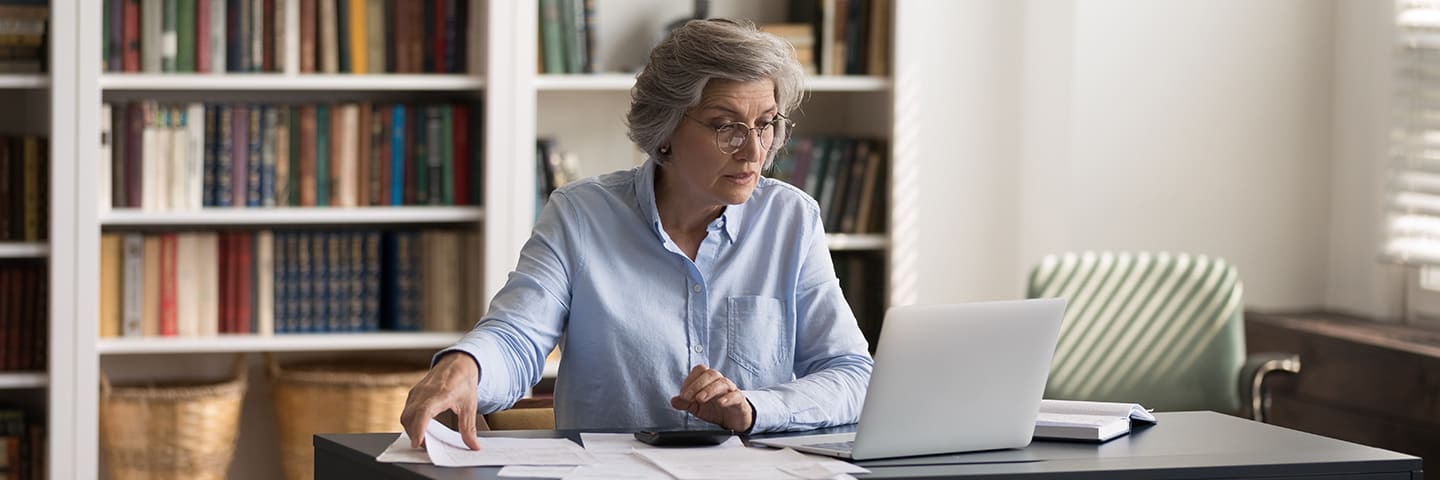 Senior sitting at desk looking at a computer