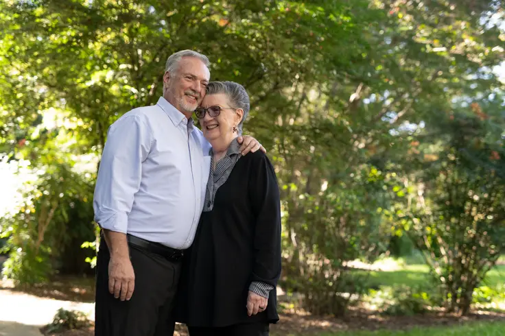 Adult son embraces his older mother outdoors, representing the family relationships behind caregiving statistics.
