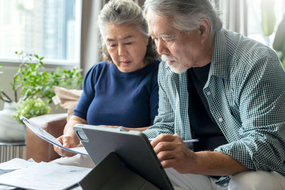 A senior couple researches home care payment options