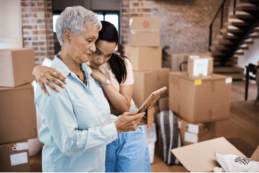 A family caregiver helps a senior pack boxes