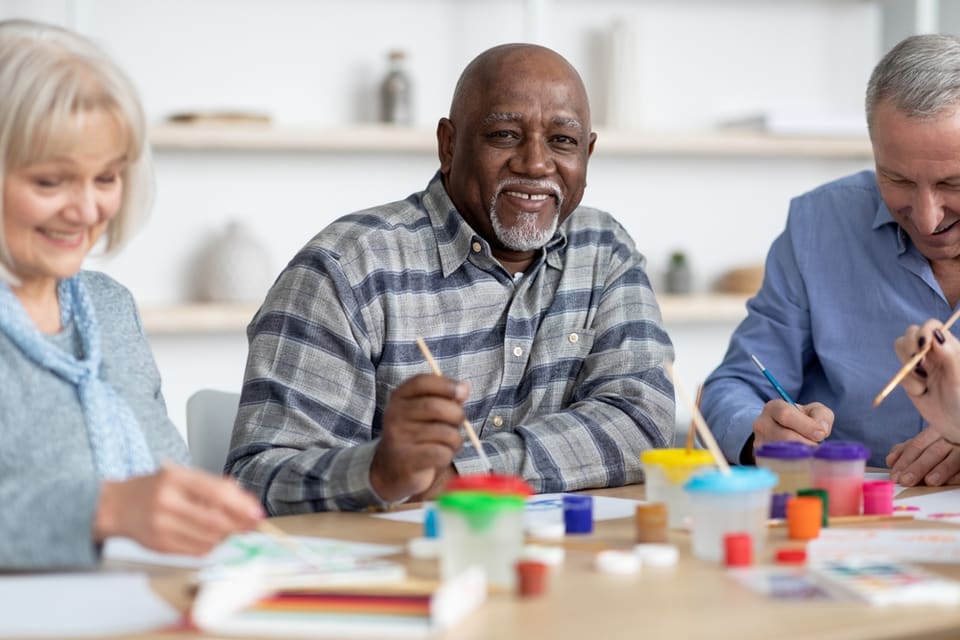 Group of seniors sitting at table participating in art activities