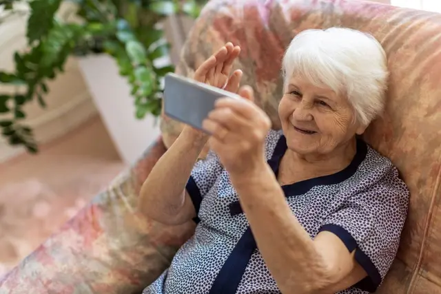 Elderly woman talks on the phone.