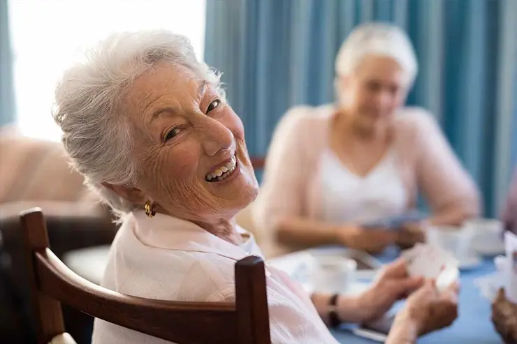 Elderly women playing cards in a senior living facility.