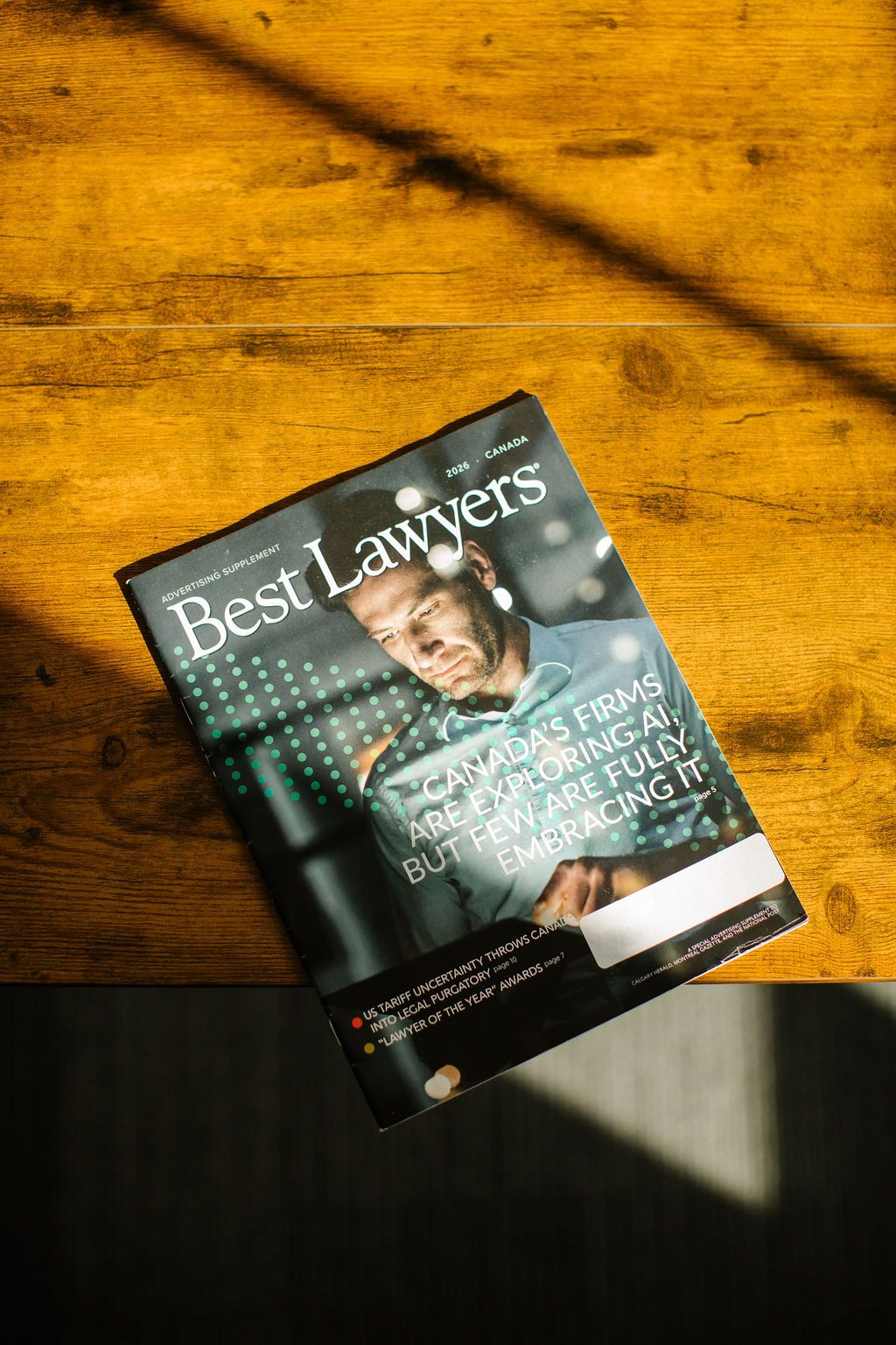 An overhead view of Best Lawyers magazine placed on the edge of a wooden table.