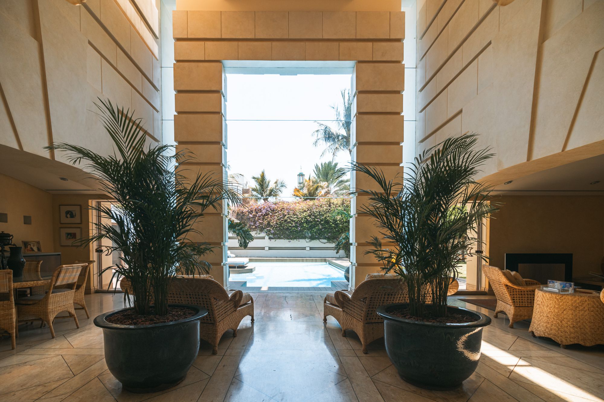 Sunlit entrance hall opening onto a pool terrace — MH House, a Mohamed Harasani Architects residential project