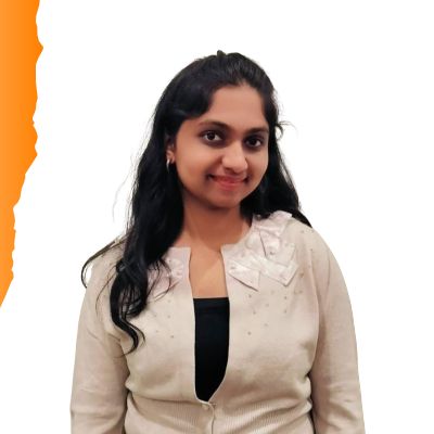 A portrait photo of Kanvitha M, a young woman with long dark hair, wearing a light beige cardigan over a dark top, smiling at the camera.