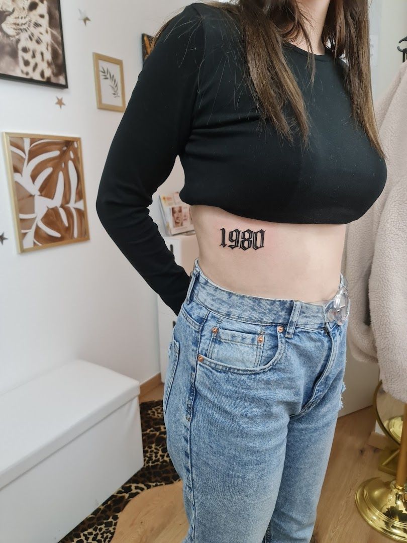 a woman wearing a black crop top and jeans