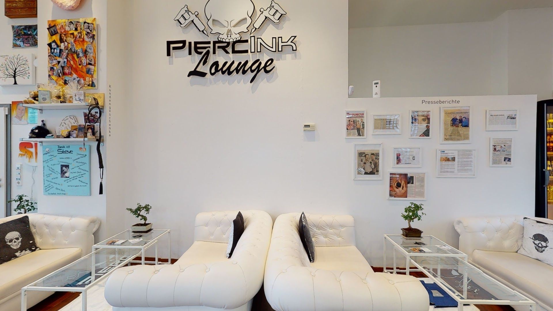 a living room with white couches and a large wall