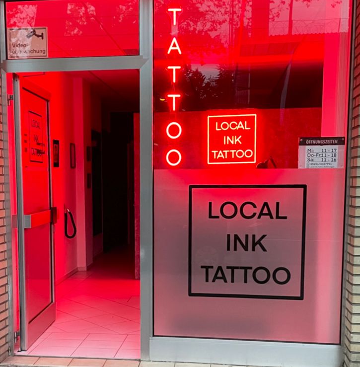 a red door with a sign that says local ink narben tattoo, paderborn, germany