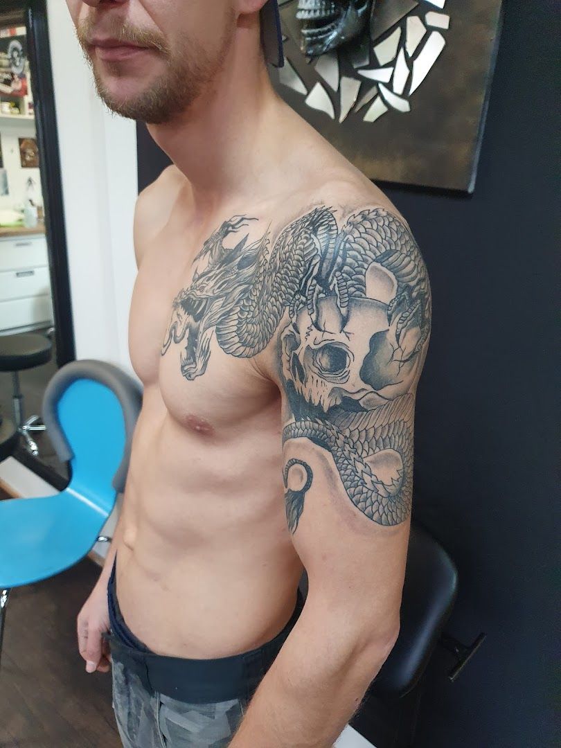 a man with a dragon cover-up tattoo on his arm, ansbach, germany