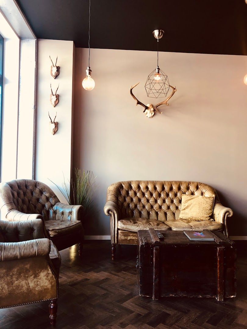 a living room with two chairs and a deer head on the wall