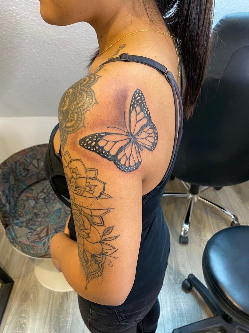 a woman with a butterfly cover-up tattoo on her shoulder, diepholz, germany