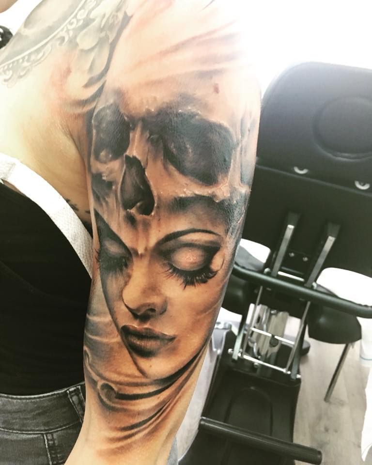 a woman's face with a skull on her arm