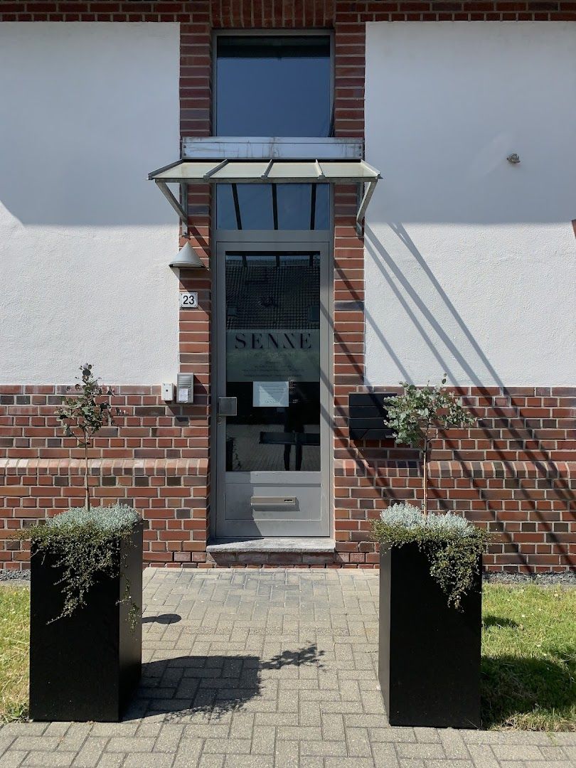 a brick building with two black planters outside