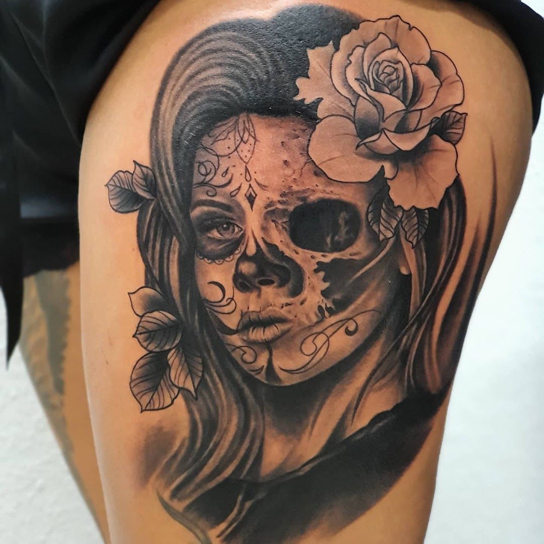 a woman with a skull and roses on her shoulder