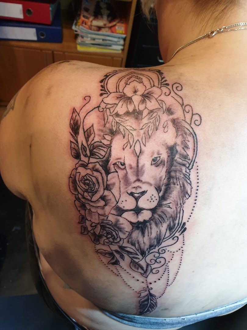a narben tattoo of a lion with roses on the back, ammerland, germany