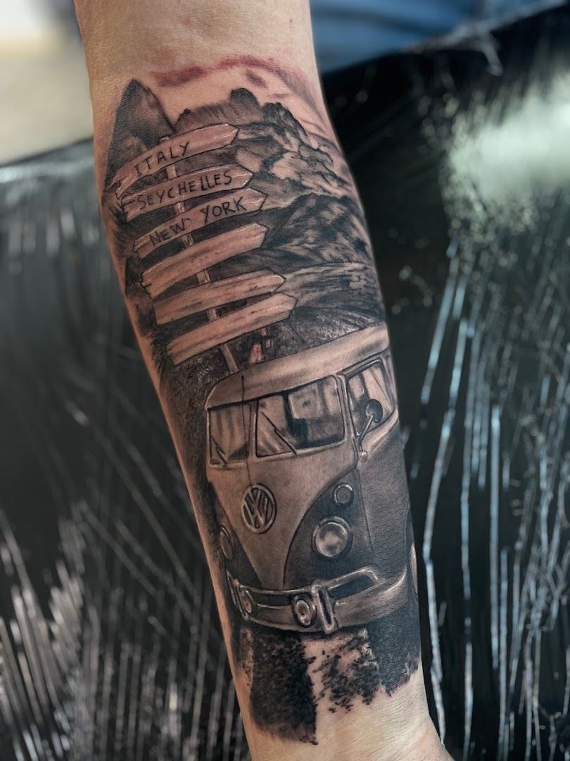 a black and white cover-up tattoo of a van with mountains and a mountain, berlin, germany