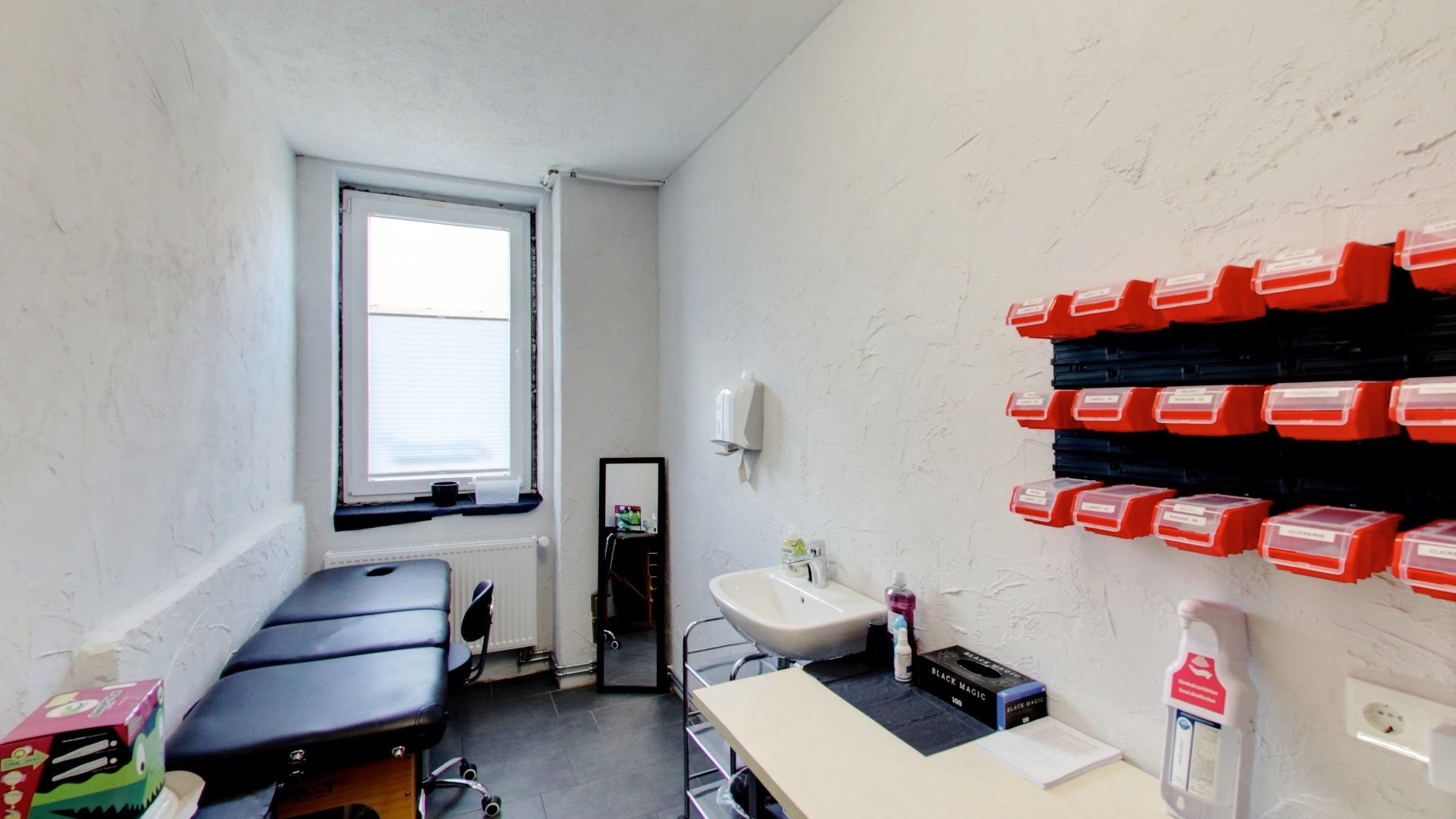 a room with a desk, a chair and a shelf