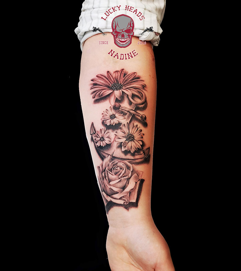 a woman's arm with a cover-up tattoo of flowers, steinburg, germany