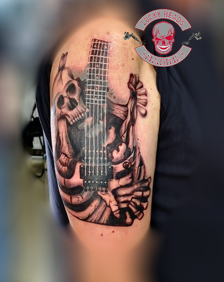 a cover-up tattoo of a guitar and a skull, steinburg, germany