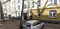 a white car parked in front of a yellow building