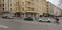 a street with cars parked on it and buildings in the background