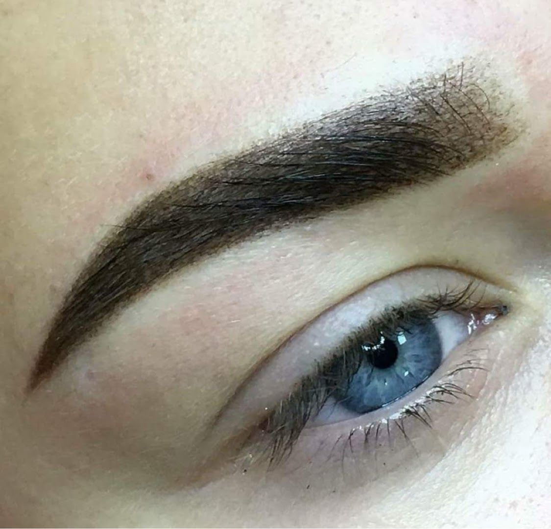 a woman's blue eyes with a eyebrow