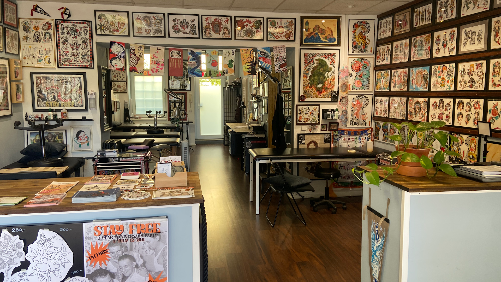 a room with a desk, a computer, and a wall of comics