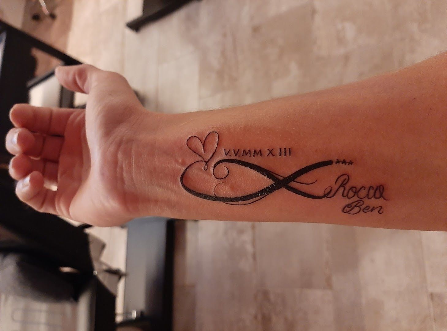 a woman's wrist with a narben tattoo saying love, dahme-spreewald, germany