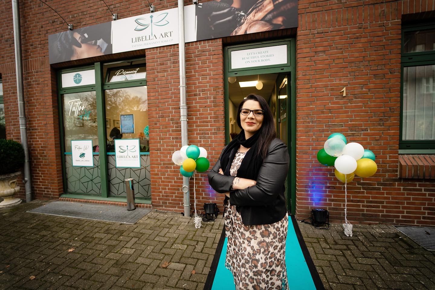 a woman standing outside of a building holding balloons