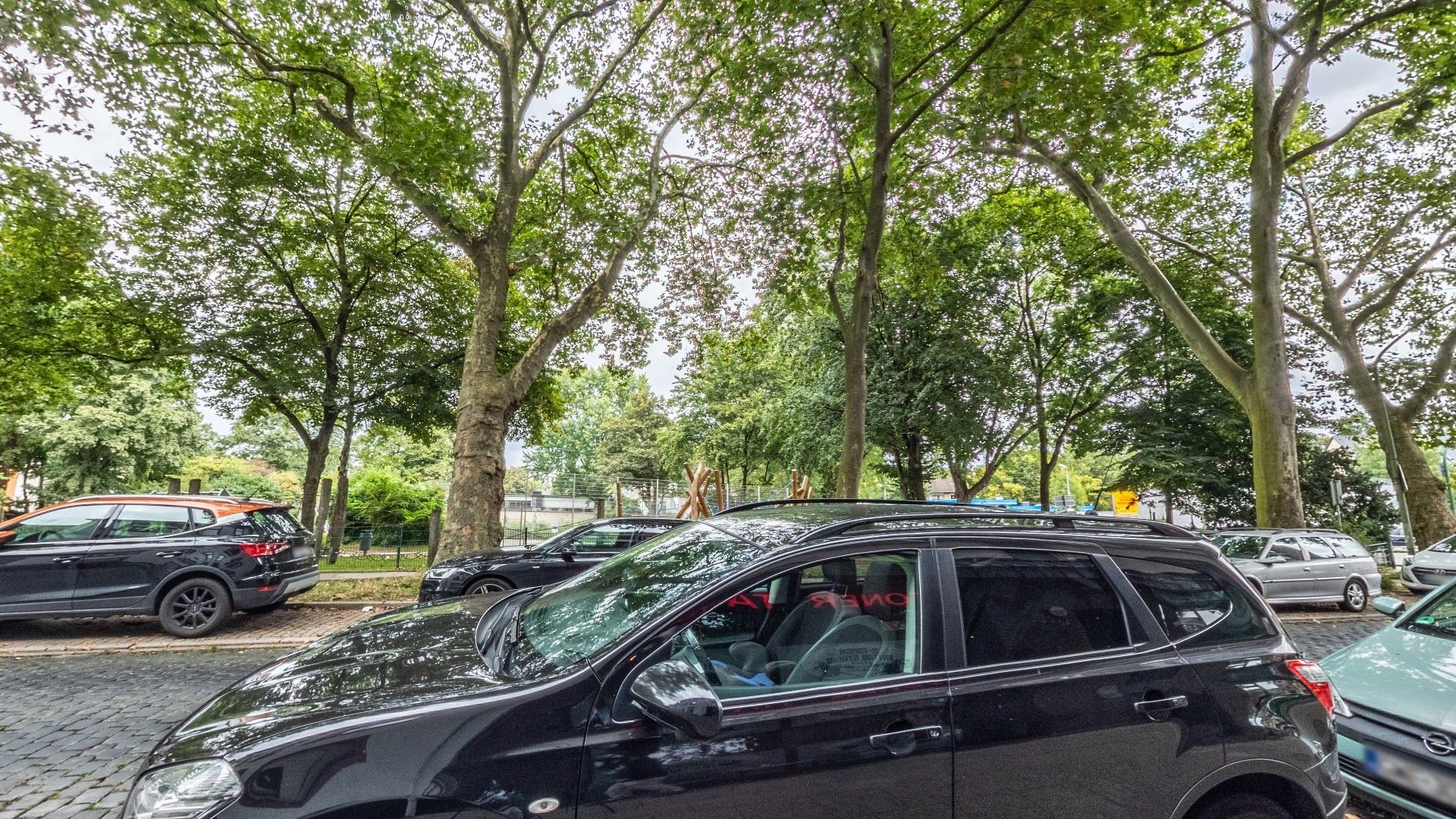 a black car parked on the side of a road