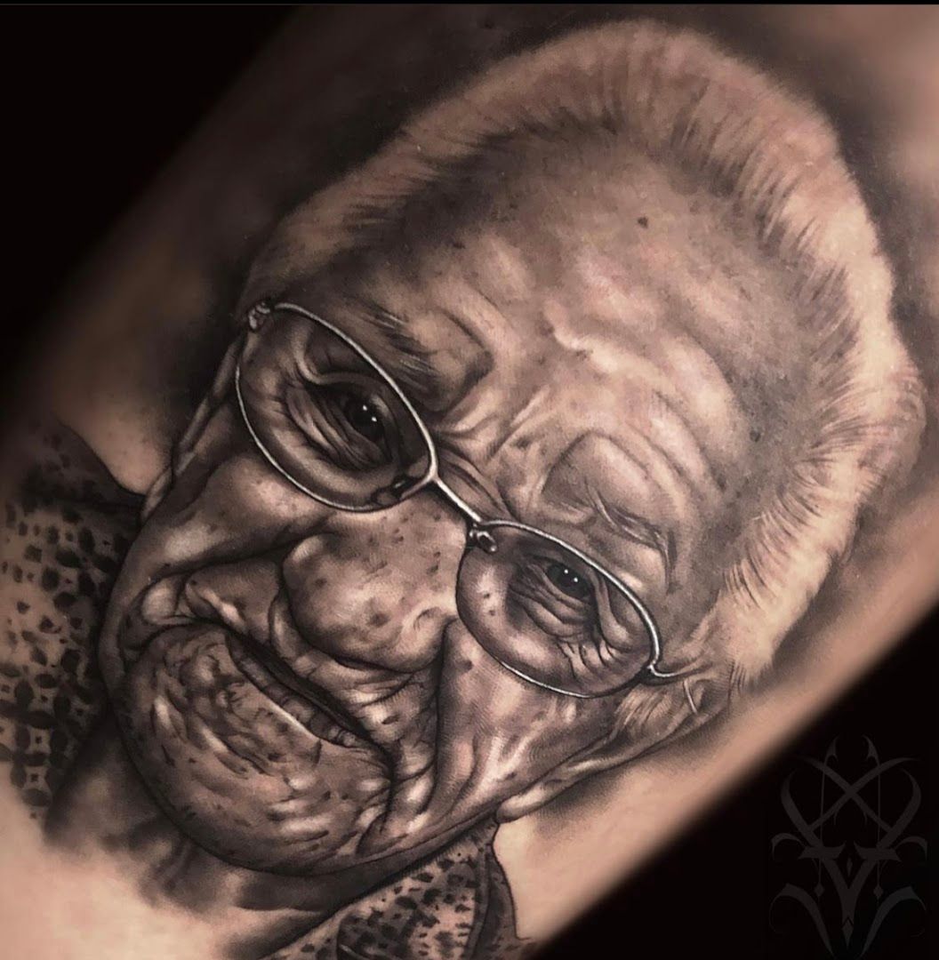 a cover-up tattoo of an old man with glasses and a bow, nürnberg, germany