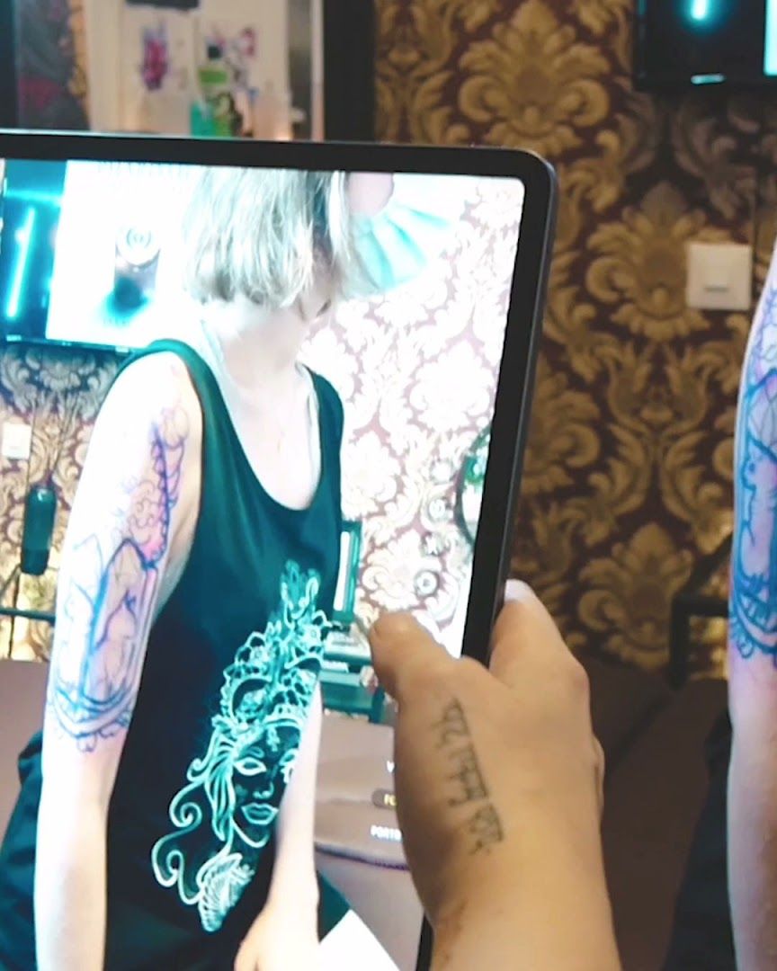 a person holding a tablet with a cover-up tattoo on it, bielefeld, germany