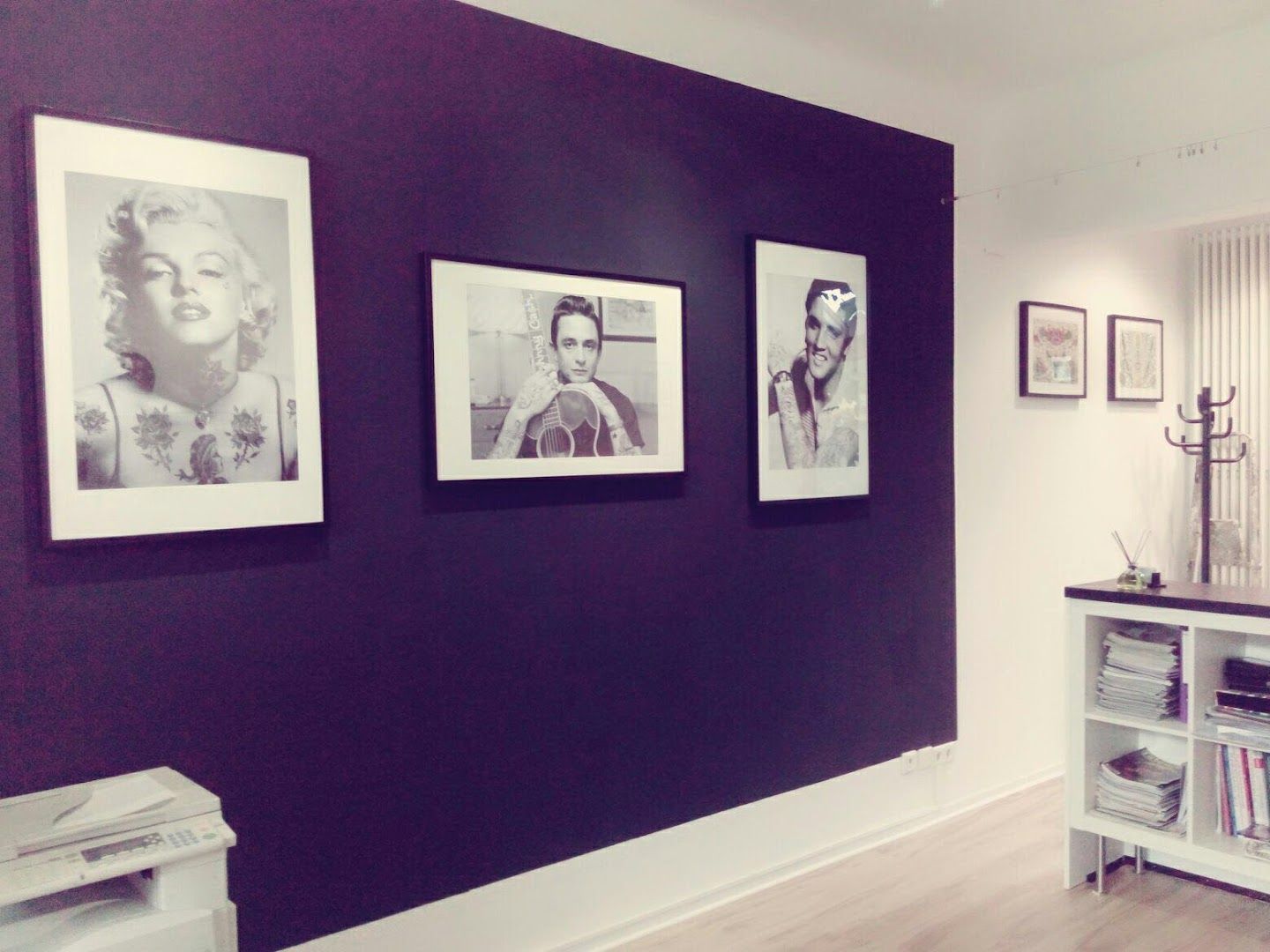 a black wall with pictures hanging on it