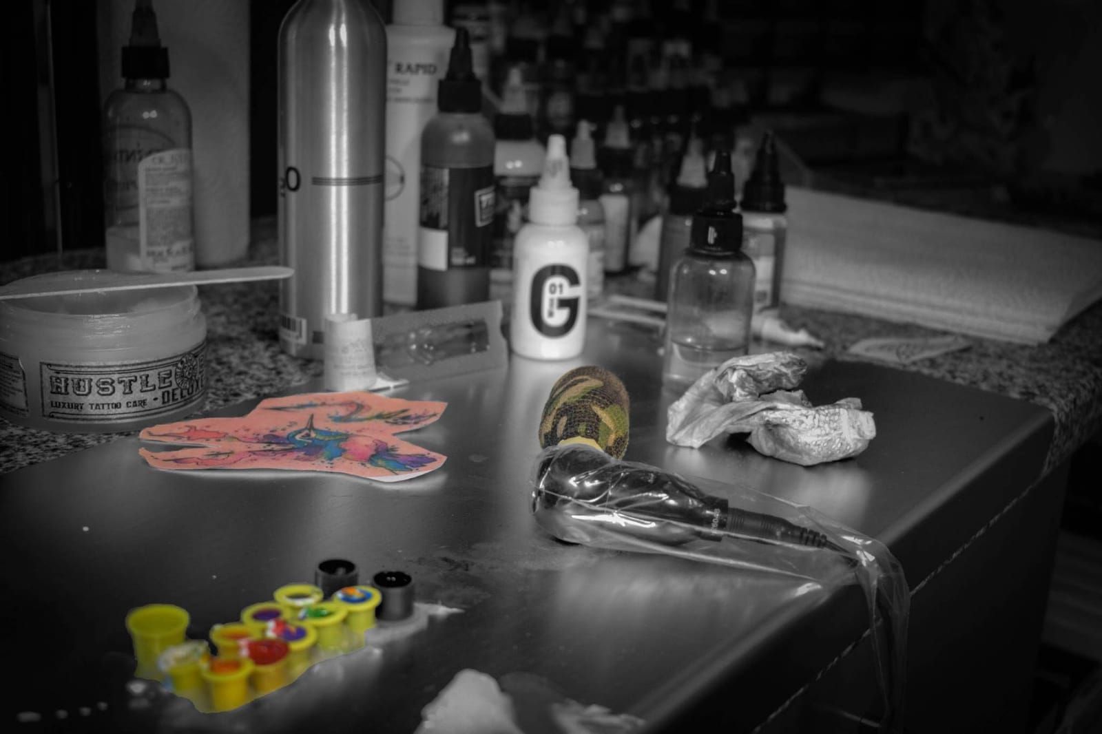 a sink with a bunch of paint and a bottle of water