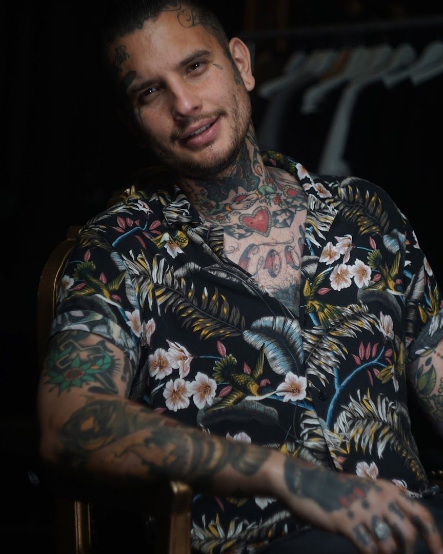 a man with narben tattoos sitting in a chair, dresden, germany