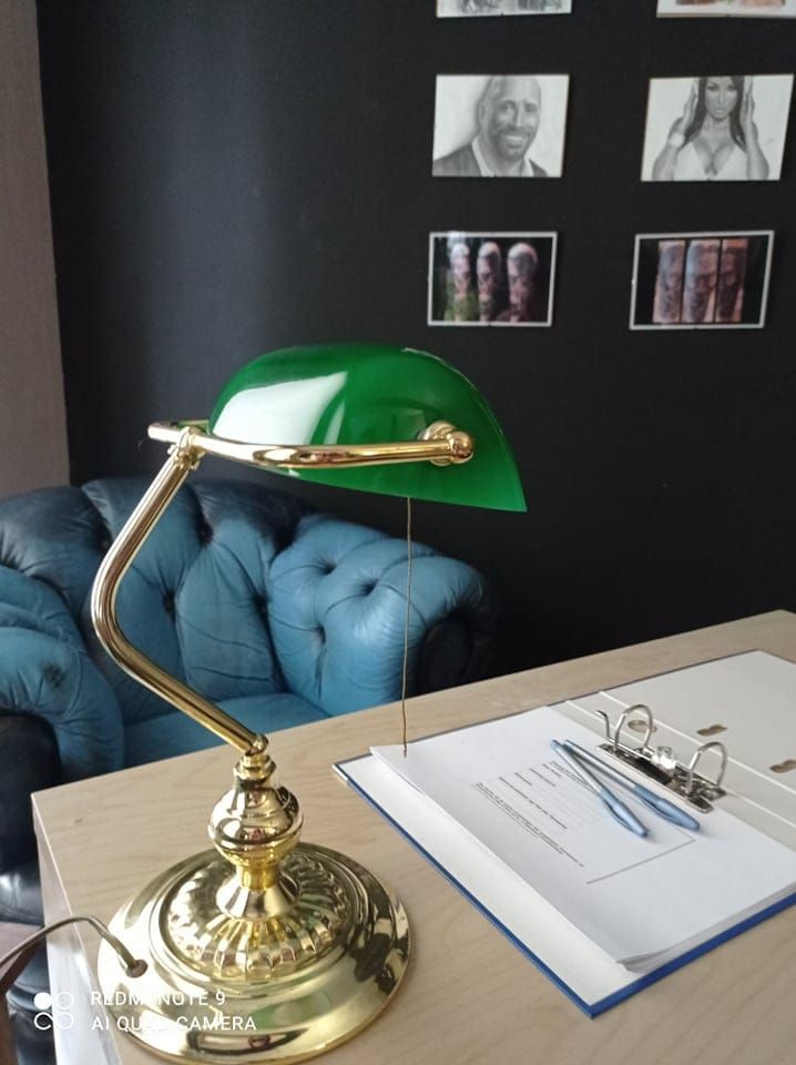 a green lamp sitting on top of a wooden table