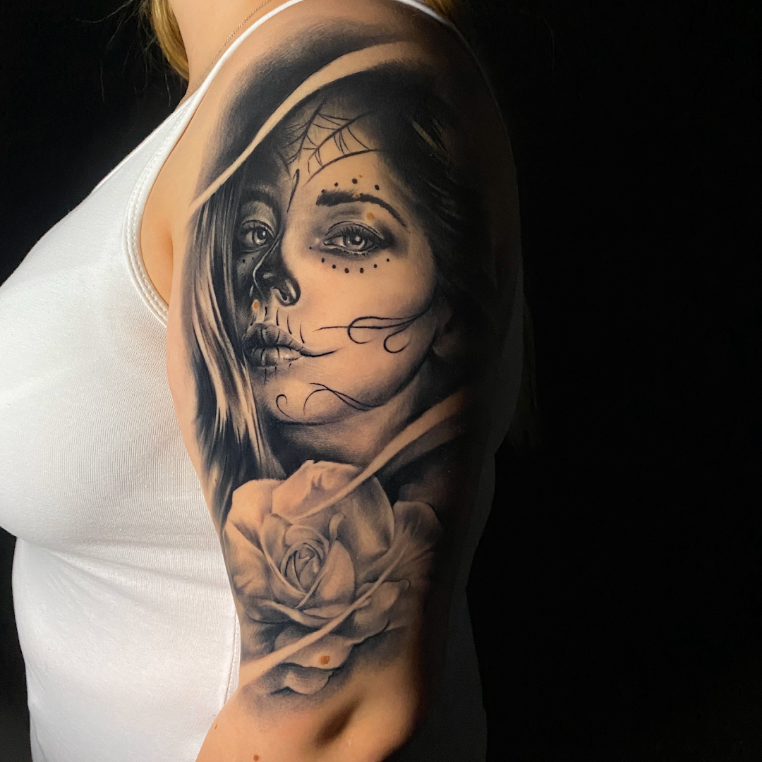 a woman with a skull and roses cover-up tattoo on her arm, bochum, germany